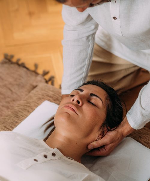 Therapist stretching woman’s neck. Shiatsu massage.